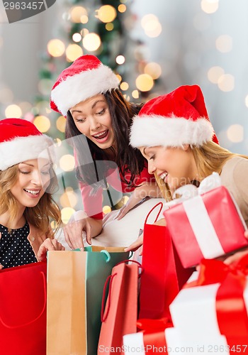 Image of smiling young women in santa hats with gifts