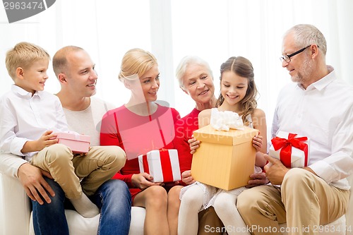 Image of smiling family with gifts at home