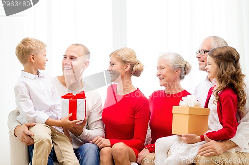 Image of smiling family with gifts at home