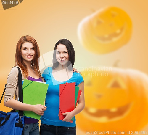 Image of smiling student girl with books and bag