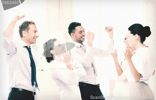 Image of business team celebrating victory in office