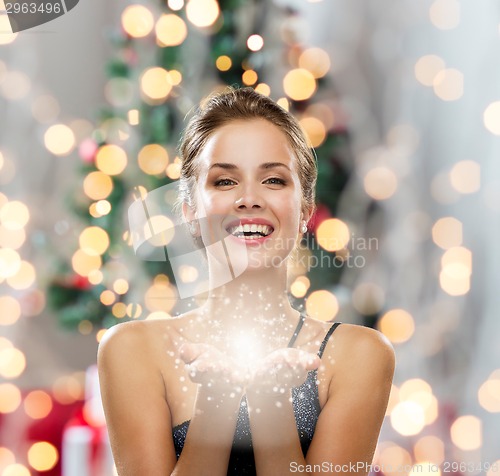 Image of laughing woman in evening dress holding something