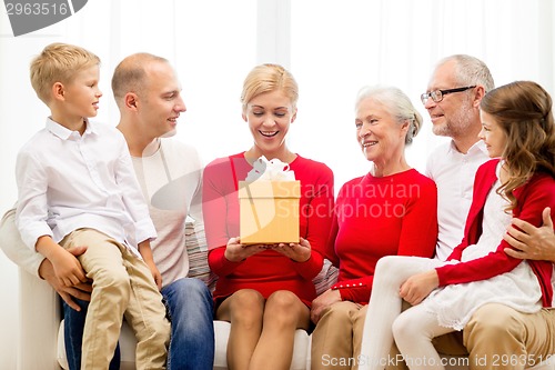Image of smiling family with gift at home
