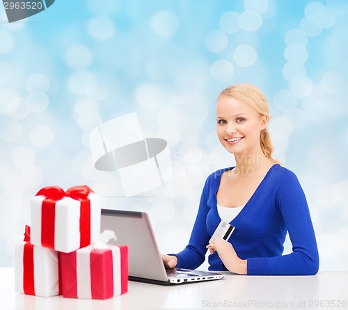 Image of smiling woman with credit card and laptop
