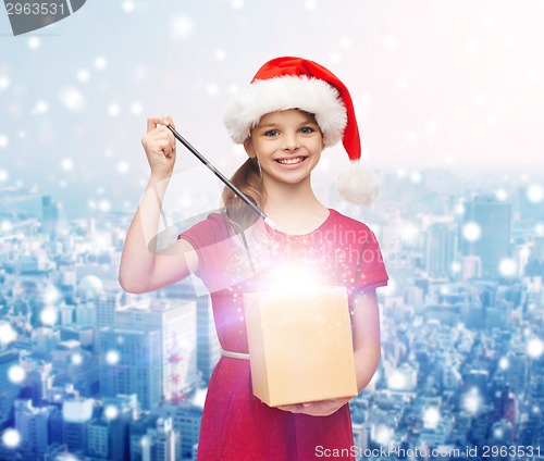 Image of smiling girl in santa helper hat with gift box