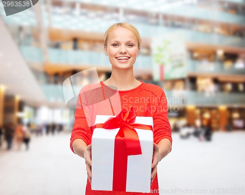 Image of smiling woman in red clothes with gift box