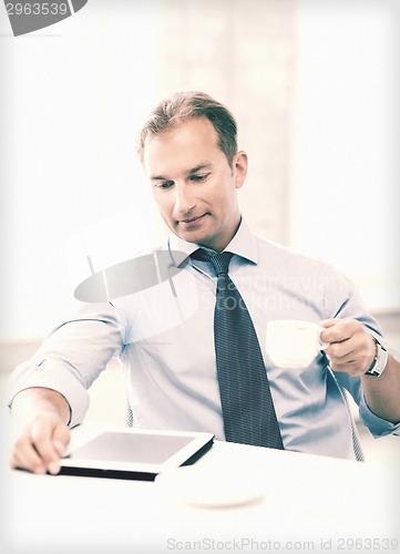 Image of businessman with tablet pc and coffee in office