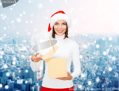 Image of smiling woman in santa helper hat with gift box