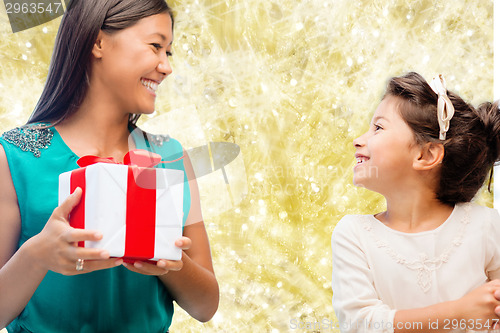 Image of happy mother and little girl with gift box