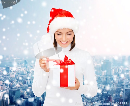 Image of smiling woman in santa helper hat with gift box