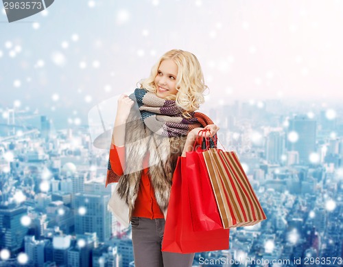 Image of smiling young woman with red shopping bags