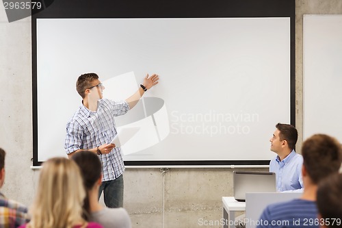 Image of group of smiling students and teacher in classroom