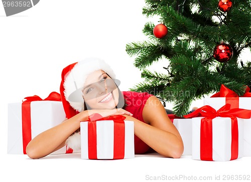 Image of smiling woman in santa helper hat with gift boxes