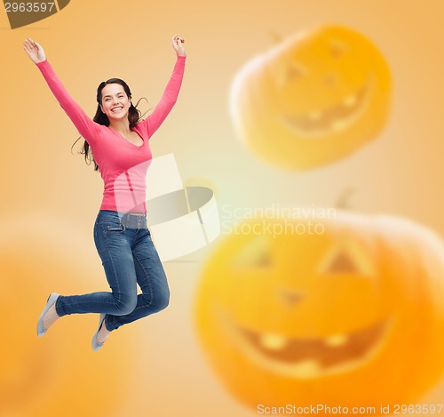 Image of smiling young woman jumping in air