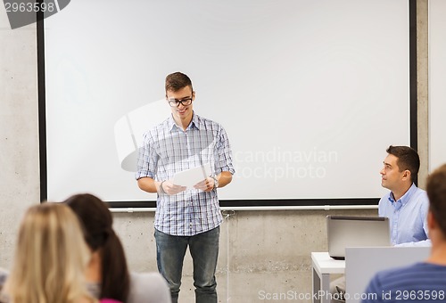 Image of group of smiling students and teacher in classroom