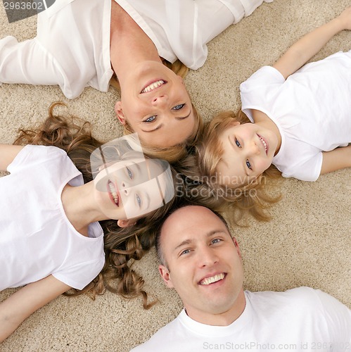 Image of parents and two girls lying on floor at home