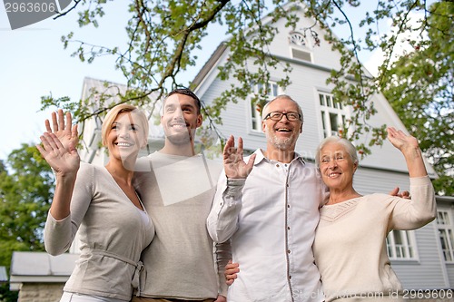 Image of happy family in front of house outdoors