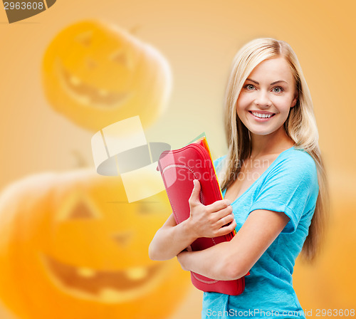 Image of smiling student girl with books and tablet bag