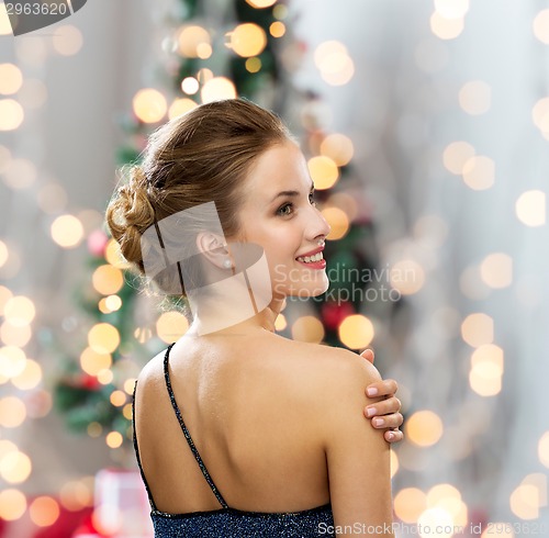 Image of smiling woman in evening dress wearing earrings