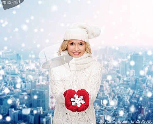 Image of smiling woman in winter clothes with snowflake