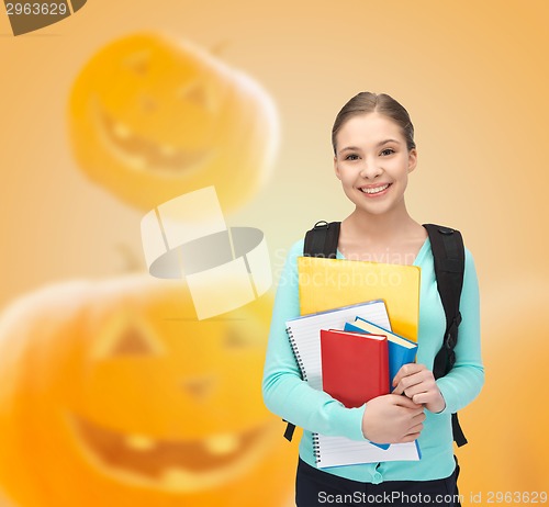 Image of smiling student girl with books and backpack