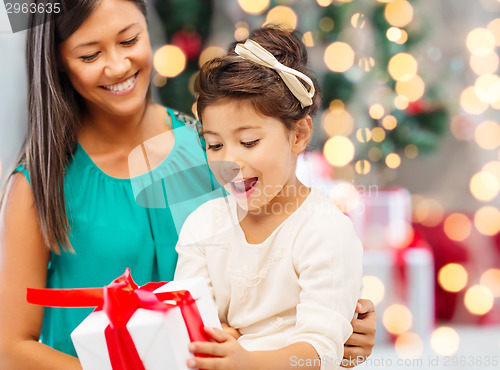 Image of happy mother and little girl with gift box