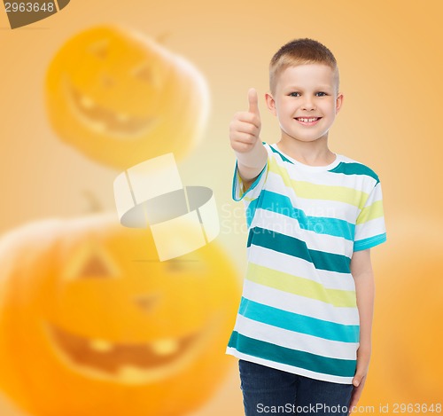 Image of smiling boy over pumpkins background