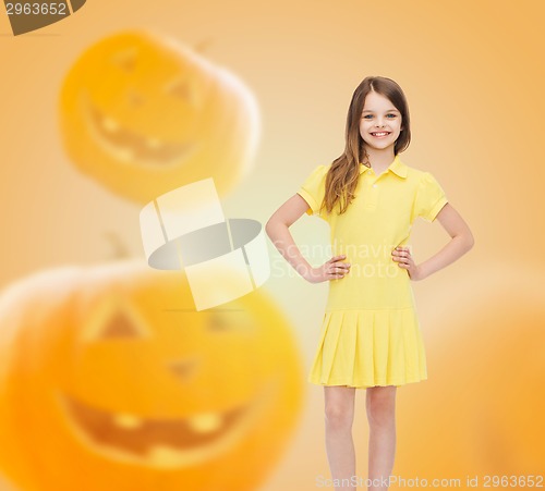Image of smiling girl in dress over pumpkins background