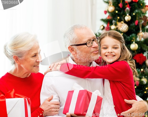 Image of smiling family with gifts at home