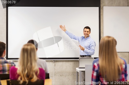 Image of group of students and smiling teacher with notepad