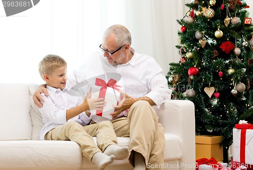 Image of smiling grandfather and grandson at home