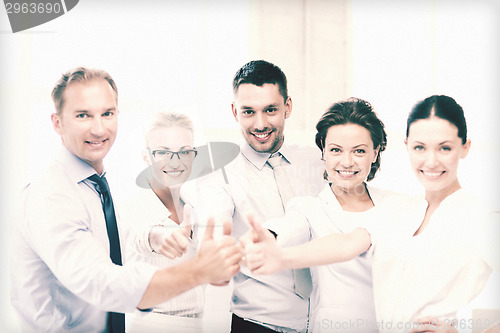 Image of business team showing thumbs up in office