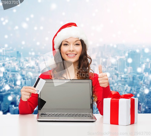 Image of smiling woman with credit card and laptop