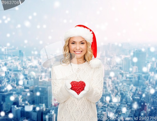 Image of smiling woman in santa helper hat with red heart