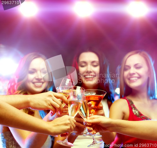 Image of three smiling women with cocktails and disco ball