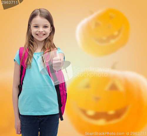Image of smiling girl in glasses over pumpkins background