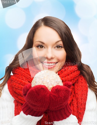 Image of smiling woman in winter clothes with snowball