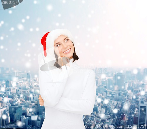 Image of thinking and smiling woman in santa helper hat