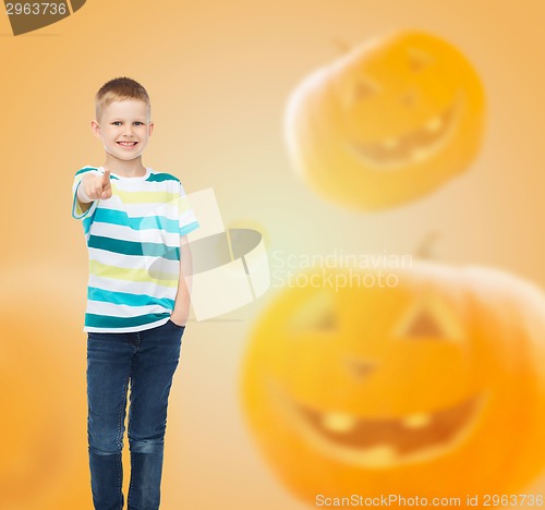 Image of smiling boy over pumpkins background