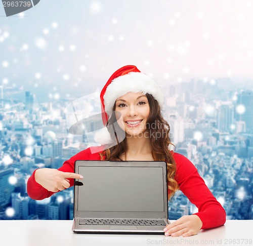 Image of smiling woman in santa helper hat with laptop