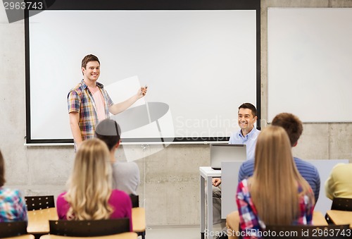 Image of group of students and smiling teacher in classroom