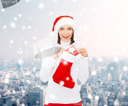 Image of woman in santa hat with gift box and stocking