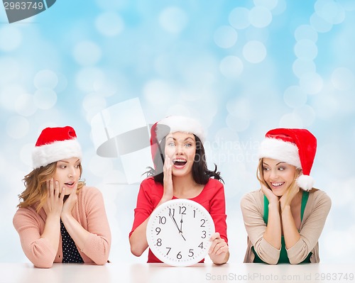Image of smiling women in santa helper hat with clock