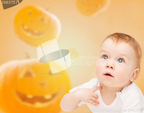 Image of smiling baby over pumpkins background