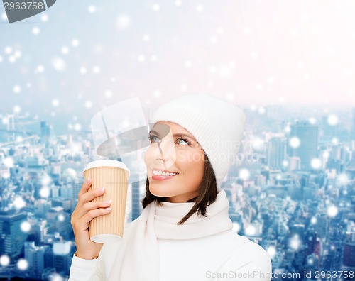 Image of smiling young woman in winter clothes with cup