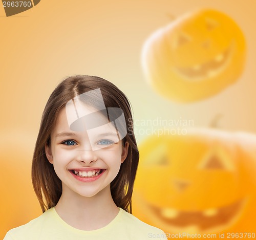 Image of smiling girl over pumpkins background