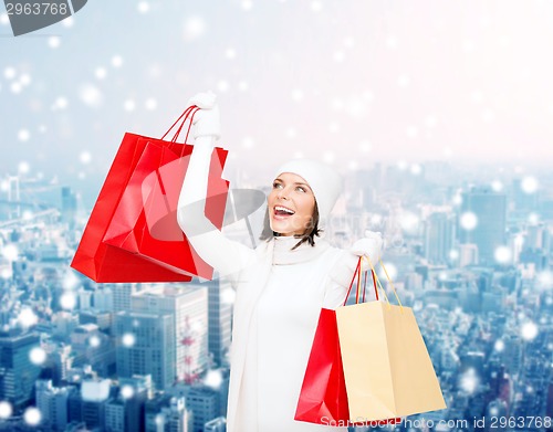 Image of smiling young woman with red shopping bags