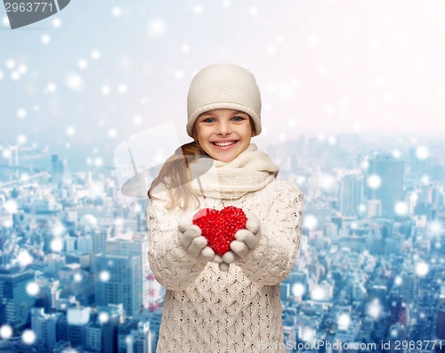 Image of dreaming girl in winter clothes with red heart