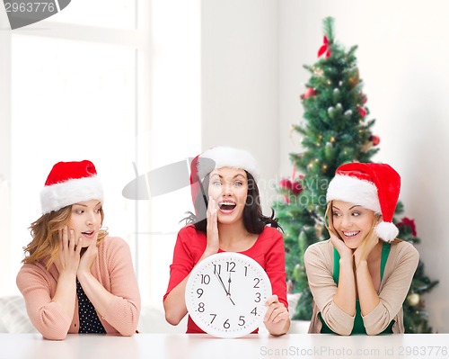 Image of smiling women in santa helper hat with clock