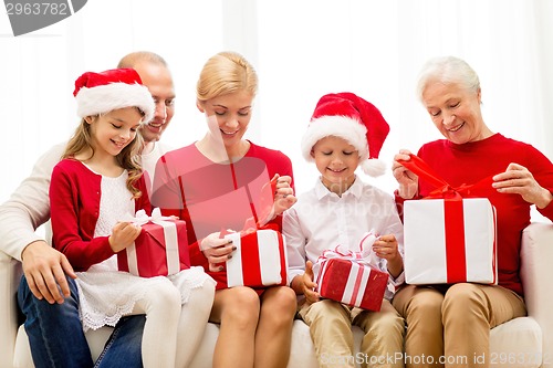 Image of smiling family with gifts at home